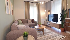 Ein modernes Wohnzimmer mit einer Couch, einem Couchtisch und einem Fernseher.