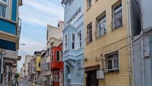 Una calle estrecha bordeada de edificios de varios pisos, con balcones y diversos estilos arquitectónicos.