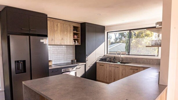 A modern kitchen with a built-in island, dark cabinetry, and a window providing natural light. - Beautiful Mountain Views (Prospect Vale)