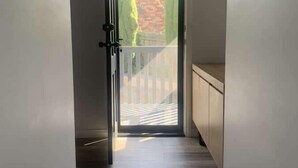 A hallway leading to a door with a view of a balcony and outdoor area. - Beautiful Mountain Views (Prospect Vale)