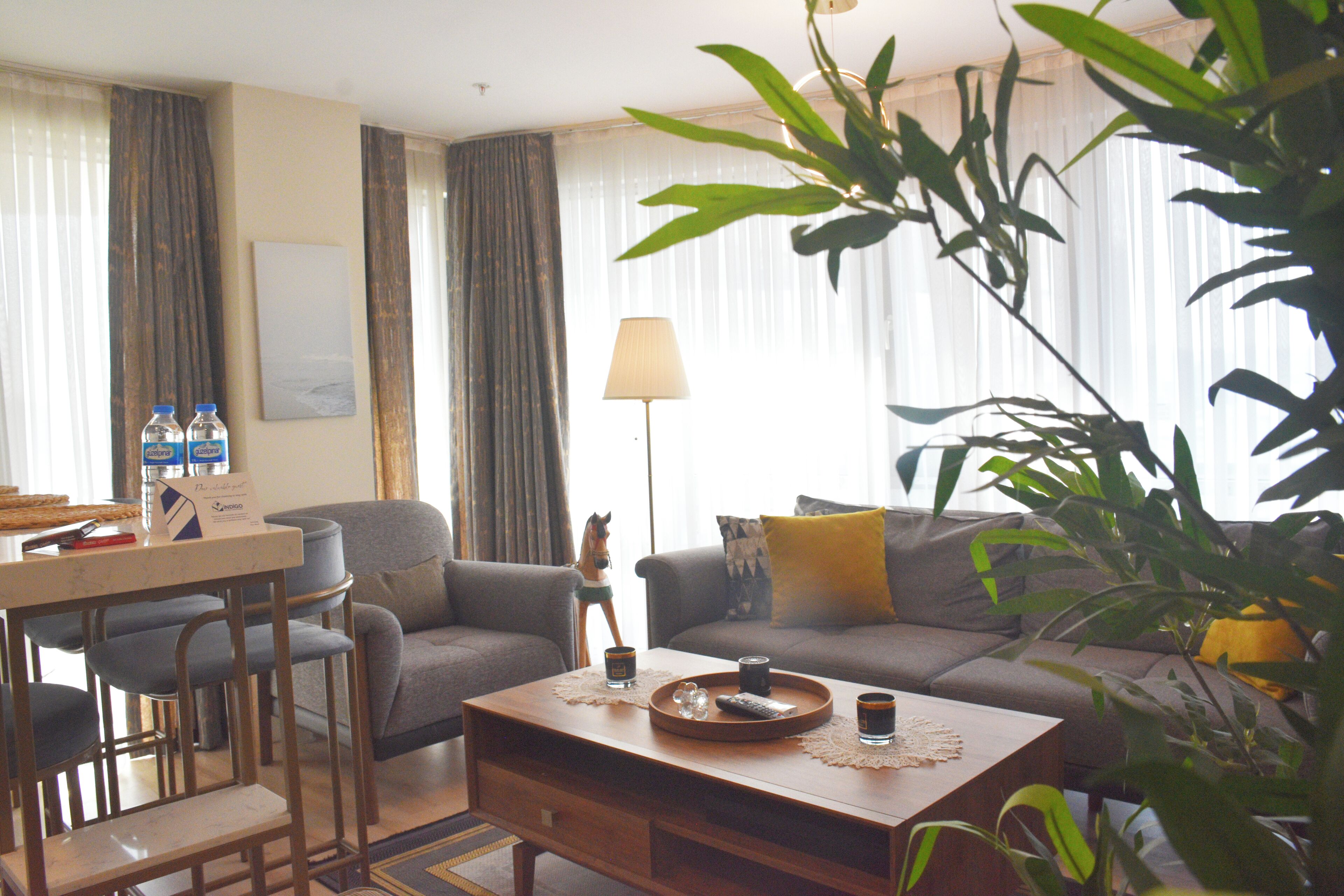 Una sala de estar con sofá, sillones, una mesa de centro y un comedor con sillas.