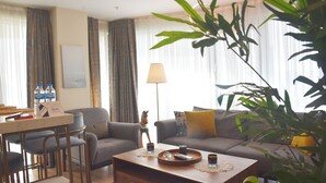 A living room with a sofa, armchairs, a coffee table, and a dining area with chairs.