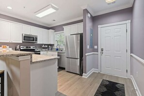 Réfrigérateur, un four, cafetière-théière, table de salle à manger