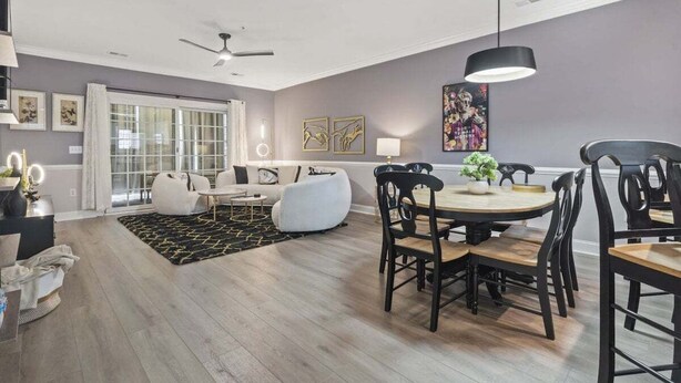 A modern living room with a sofa, chairs, a dining table, and a ceiling fan. - Oh Gosh! So Posh in Myrtlewood Villas (Myrtle Beach)