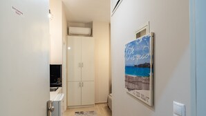 A hallway with a white wardrobe, a framed picture on the wall, and a sign indicating 'Bona's Apartments Studio 2'.