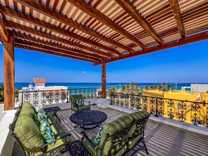 A covered outdoor seating area with a view of the ocean. - Stunning 4bdr w/private pool in Punta Sur (Isla Mujeres)
