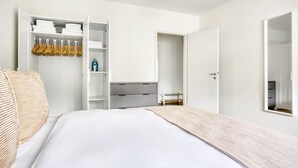 Een moderne slaapkamer met een groot bed, een inbouwkast en een inloopkast.