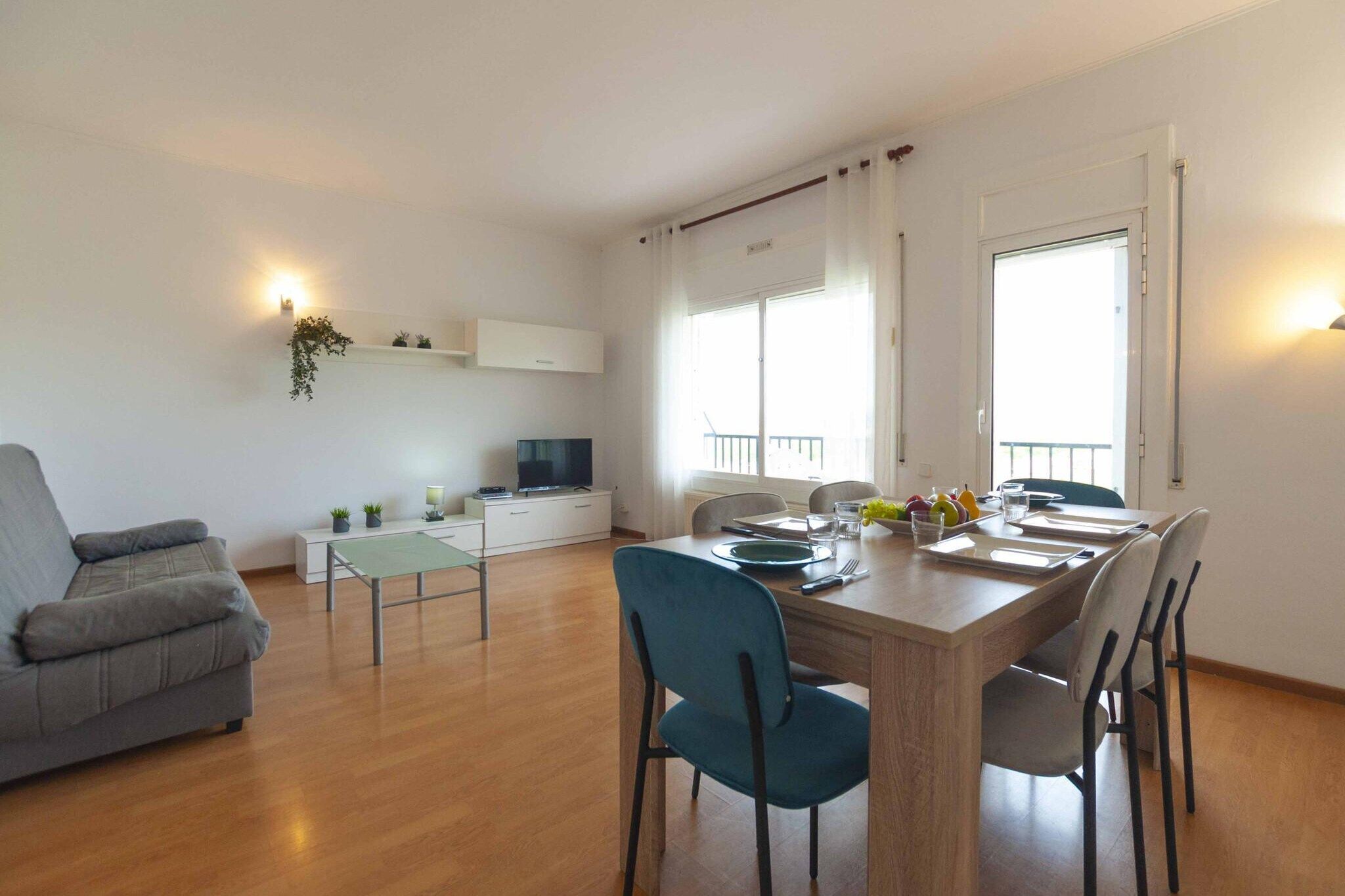 A modern living room with a grey sofa, a dining table with chairs, a TV, and a balcony with a railing.