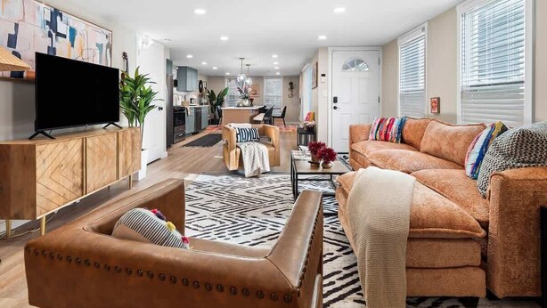 A modern living room with a sofa, a coffee table, and a TV on a wooden cabinet.