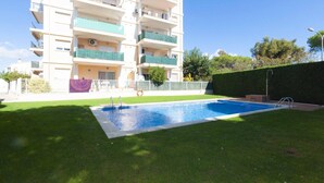 Un edifici residencial amb piscina, balcons i un jardí ben cuidat.