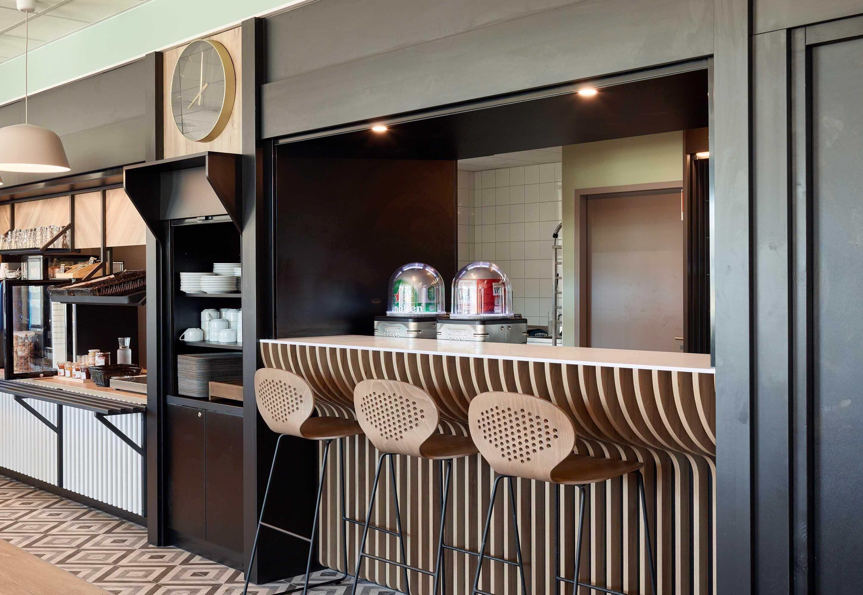 A bar area with a counter, stools, and a clock.