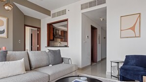 A modern living room with a grey sofa, a blue armchair, and a coffee table with books.