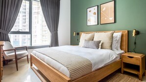 A modern bedroom with a large bed, a chair, a bedside table, and a view of buildings through the window. - Blueground | Downtown Dubai, pool, nr Burj Khalifa (Dubai)