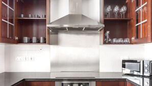 A modern kitchen with stainless steel appliances, wooden cabinets, and a built-in wine rack. - Blueground | Downtown Dubai, pool, nr Burj Khalifa (Dubai)