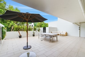 Outdoor dining - Stylish Retreat with Pool, Gym & Parking Near Palm Cove Beach (Palm Cove)