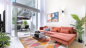 Un salon moderne avec un canapé, une table basse et une grande fenêtre.