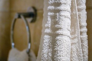 A close-up of a textured white towel hanging on a metal towel rack.