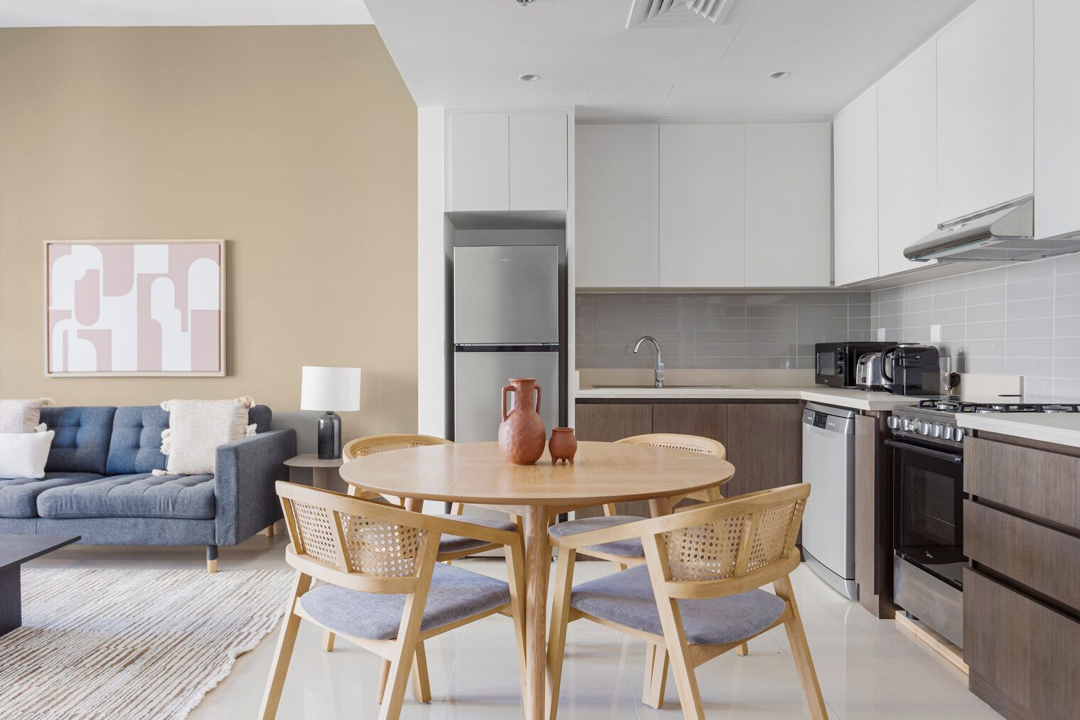 A modern kitchen with a dining area, a sofa, and a coffee table.