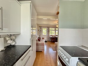 A compact kitchen with a stove, cabinets, and a dining area with a table and chairs.