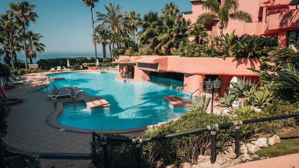 A resort pool area with multiple pools, palm trees, and a view of the ocean. - Luxury Beachfront Heated Pool & SPA & GYM–EHHouse (Loma Del Monte)