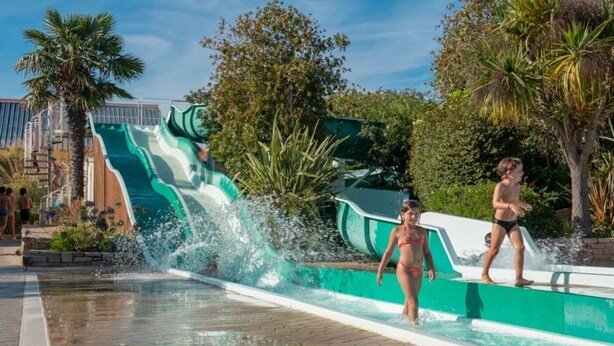 A water park with a large water slide and a pool area.
