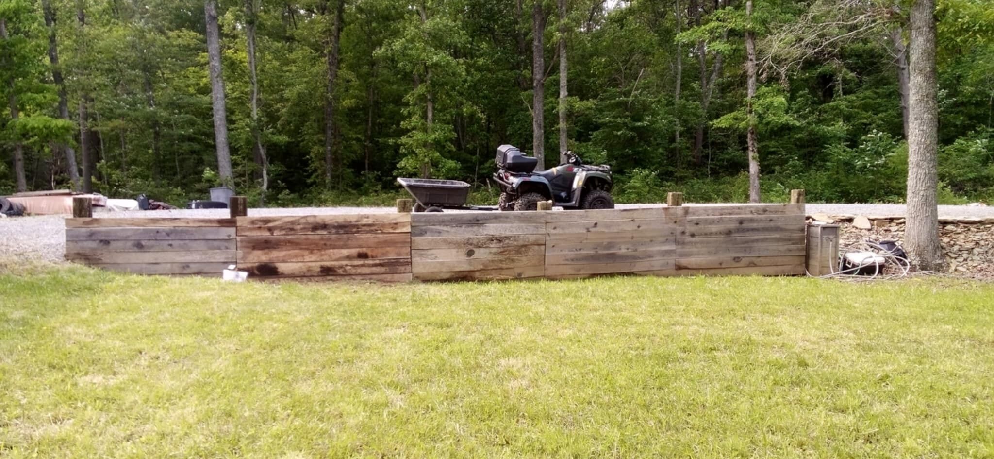 Un recinto di legno con un veicolo parcheggiato dietro.