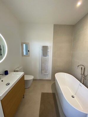 A bathroom with a white sink, toilet, and bathtub.