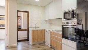 A modern kitchen with white cabinetry, a built-in microwave, and an oven.