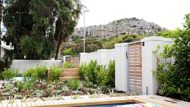 A swimming pool with a wooden deck and a colorful towel.