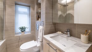Un baño moderno con inodoro, lavamanos y ducha.