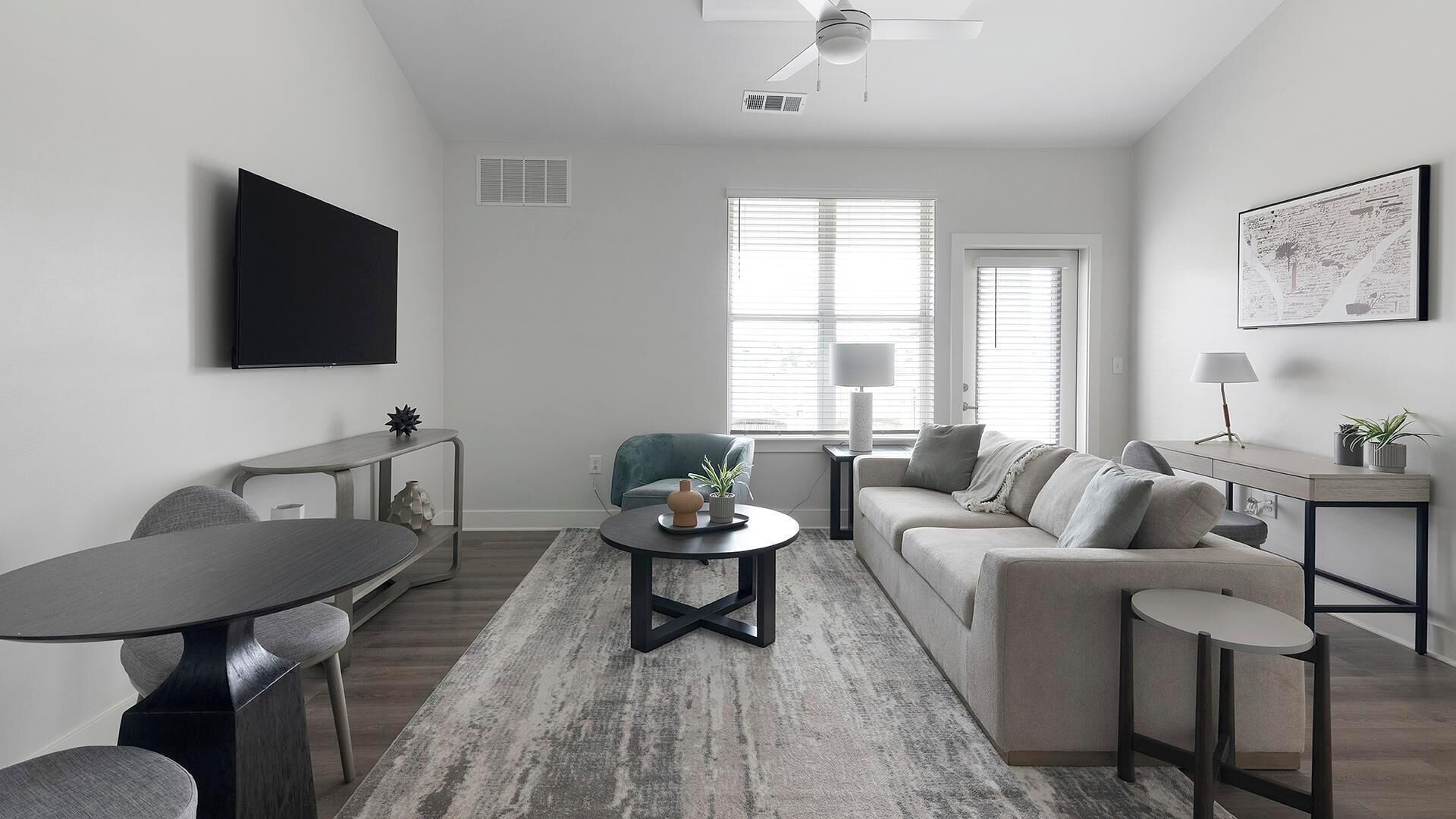 A modern living room with a sofa, coffee table, and a TV mounted on the wall.