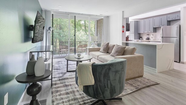 A modern living room with a sofa, a coffee table, and a TV mounted on the wall.