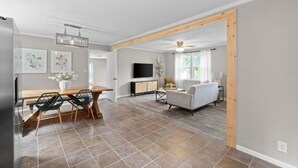 A spacious living area with a dining table, sofa, and TV.