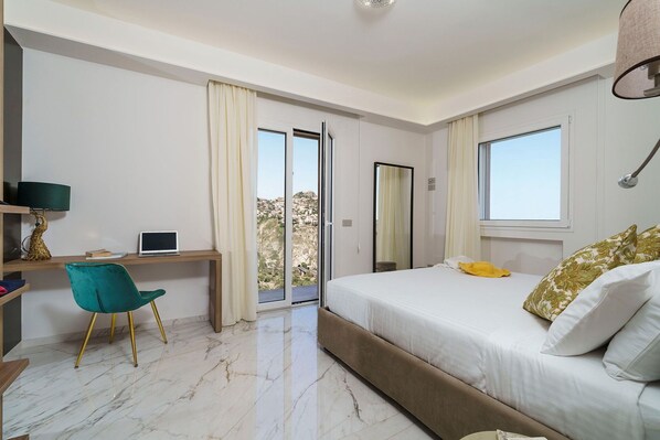 A modern bedroom with a bed, a desk, and a chair.