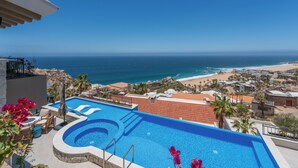 A swimming pool with a view of the ocean and beach.