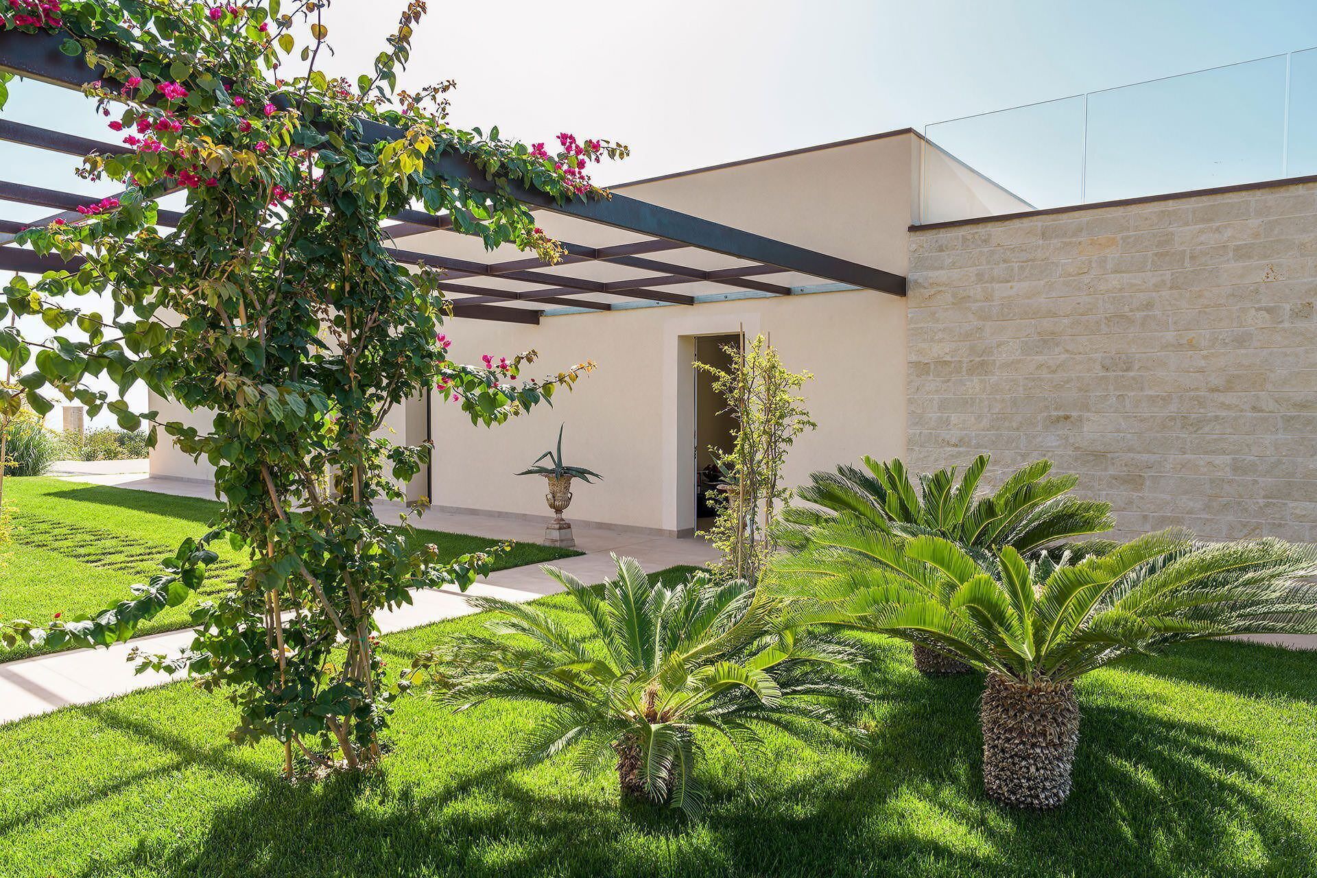 A modern building with a stone wall and a covered patio area.