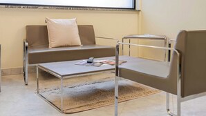 Ein modernes Zimmer mit einer Couch, einem kleinen Tisch und einem Stuhl.