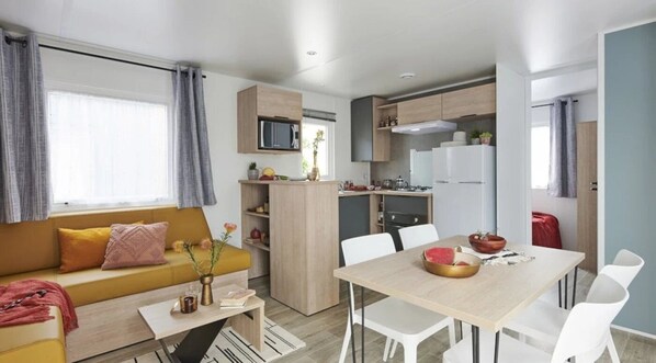A modern apartment with a living area, kitchenette, and dining space.