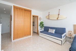 Ein modernes Wohnzimmer mit einer Couch, einem Holzschrank, einer Surfbrett-Dekoration und einem Blumentopf.