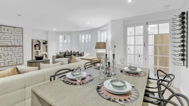 A modern dining area with a wooden table set for four, surrounded by comfortable seating. - Central Snug with Patio | By My Getaways (Worthing)