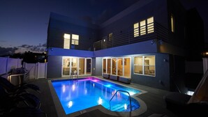 Et toetagers hus med swimmingpool i skumringen.