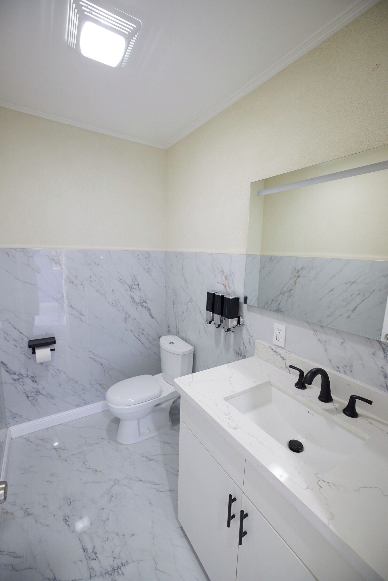 Un baño con inodoro, lavabo y espejo.