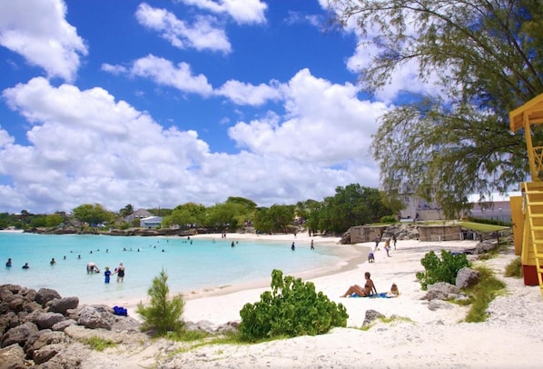Une plage à l’eau turquoise et limpide, où l’on peut se baigner et prendre des bains de soleil.