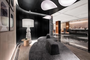 A modern lobby with a reception desk, seating area, and a large wall-mounted lamp. - City Inn Shanghai Xizang South Road Hotel (Shanghai)