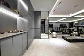 A modern gym with exercise equipment, a large mirror, and a minimalist design. - City Inn Shanghai Xizang South Road Hotel (Shanghai)
