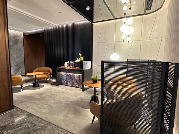 A modern reception area with a reception desk, two sofas, a coffee table, and a decorative plant. - City Inn Shanghai Xizang South Road Hotel (Shanghai)