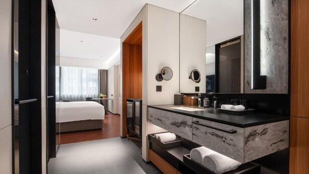 A modern hotel room with a large bed, a marble bathroom vanity, and a large mirror. - City Inn Shanghai Xizang South Road Hotel (Shanghai)