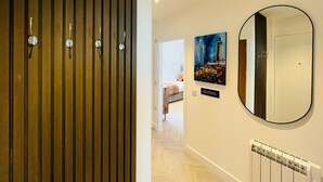 A hallway with a wooden panel wall, a radiator, and a painting on the wall. - Bramble Apartment in Fort William Town Centre (Fort William)