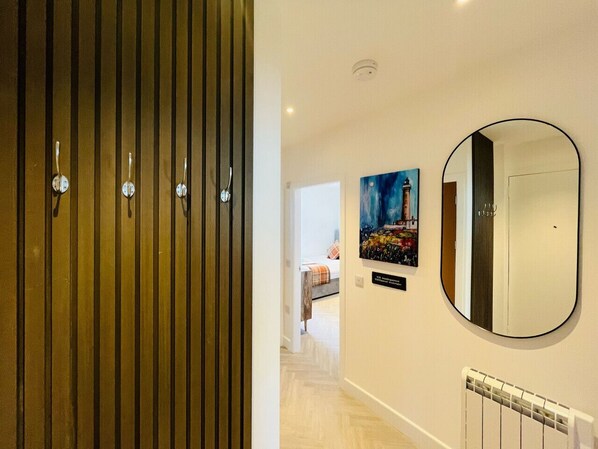 A hallway with a wooden panel wall, a radiator, and a painting on the wall.