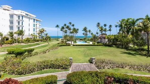 A resort with a pool, palm trees, and a view of the ocean. - Bahia Beach Steps from Ocean 3BDRM- Ocean View (Herreras)